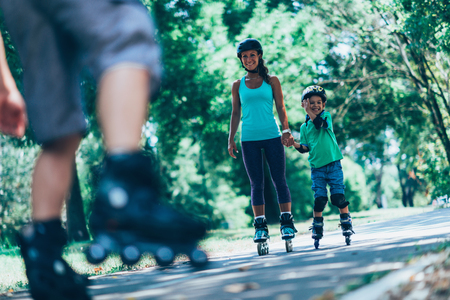 Mother and son in bacground in focus with father's roller skaters on front