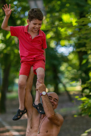 Grandfather and grandson  exercising in parkの写真素材