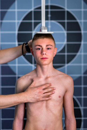 Physical Therapist measuring height of teenage boyの写真素材
