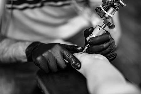 Tattoo artist tattooing young womanの写真素材