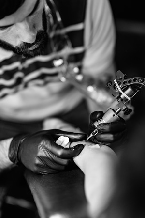 Tattoo artist tattooing young womanの写真素材