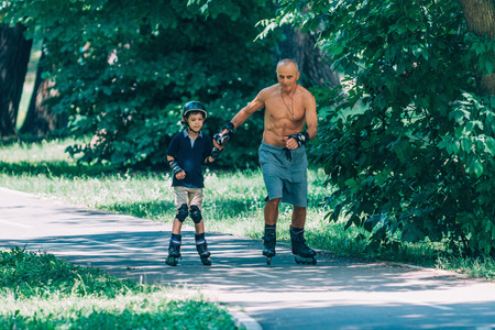 Grandfather and grandson enjoying roller skating in the park