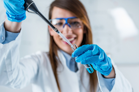 Life science research. Technician using micro pipetteの写真素材