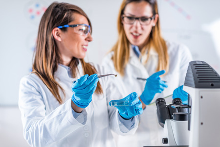 Female students researching samples in laboratoryの写真素材