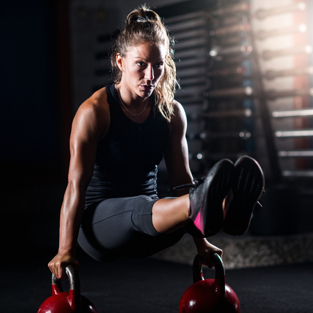 Woman athlete exercising with kettlebell