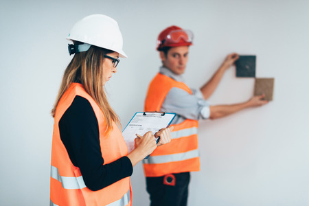 Engineers examining tiles on construction siteの写真素材