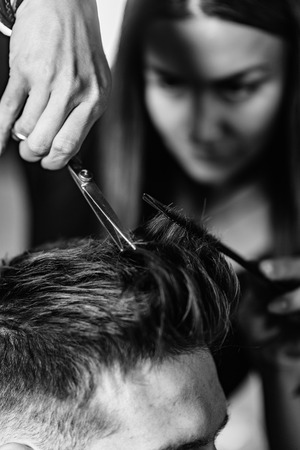 Hair styling man in hairsalon by female hairdresserの写真素材