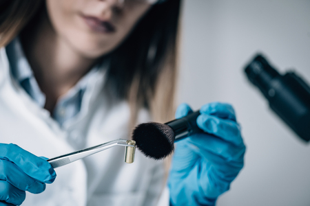 Forensic Science in Lab. Forensic Scientist examining bullet shell with evidencesの写真素材