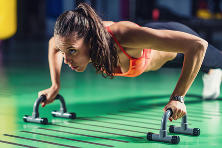 Woman doing push-ups in the gymの写真素材
