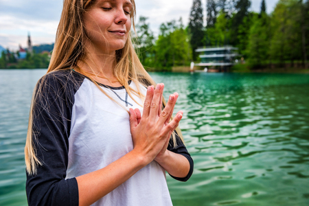 Woman doing yoga by the lakeの写真素材