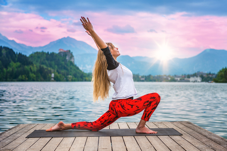 Woman doing yoga by the lakeの写真素材