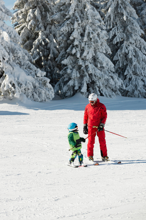 Ski trainer and little boy skiingの写真素材