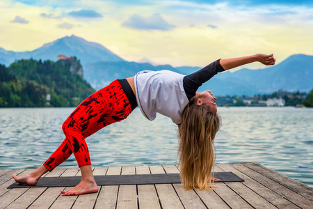 Woman doing yoga by the lakeの写真素材