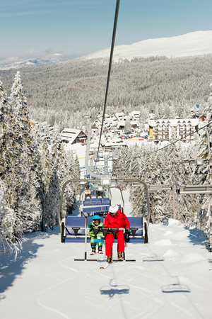 Ski instructor with little boy on ski liftの写真素材