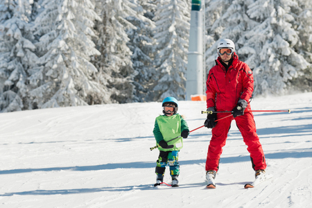 Ski instructor learning little boy skiingの写真素材