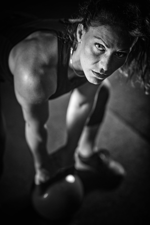 Woman athlete exercising with kettlebell indoorsの写真素材