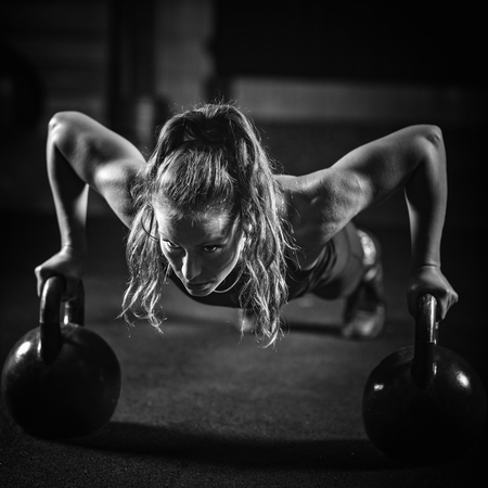 Woman athlete exercising with kettlebell indoorsの写真素材