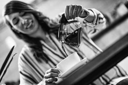 Woman pouring coffee from kettleの写真素材