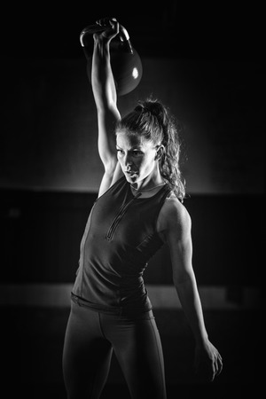Woman athlete exercising with kettlebell indoorsの写真素材