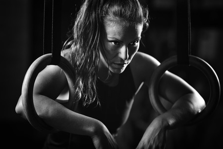 Woman athlete exercising on gymnastic ringsの写真素材