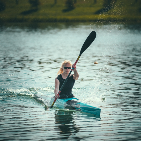 Female kayaker training on lake