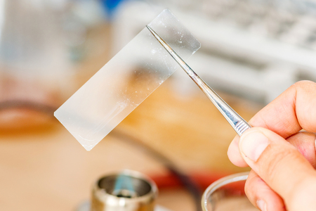 Laboratory work, holding microscope slide over flameの写真素材