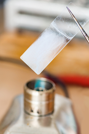 Laboratory work, holding microscope slide over flameの写真素材