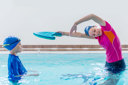 Boy having a swimming lesson with instructorの写真素材