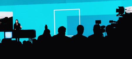 Group of journalists recording event, audience listening speech at the conference hall, silhouettesの写真素材