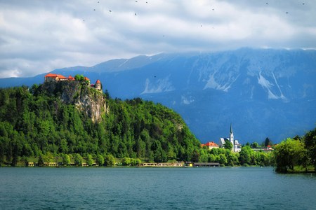 Beautiful medieval castle on Bled lake in Slovenia with mountains in backgroundのeditorial素材