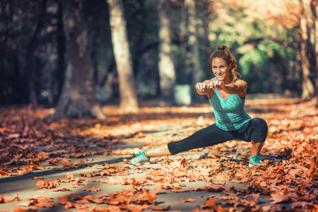Woman stretching in the park, in the fall.の写真素材