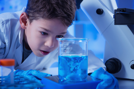 Schoolboy using lab equipmentの写真素材
