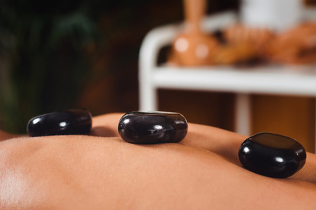 Close up of woman having hot stone massage in spaの写真素材