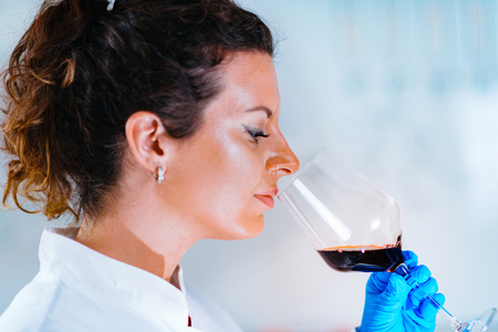 Quality control expert inspecting red wine in the laboratoryの写真素材