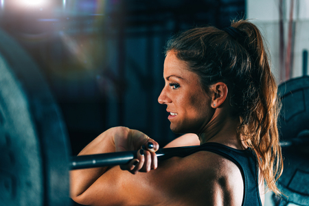 Cross training. Female athlete lifting heavy barbellsの写真素材