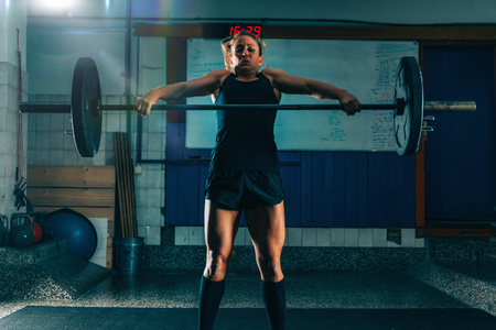 Cross training. Female athlete lifting heavy barbellsの写真素材