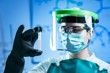 Cryopreservation. Biobanking technician in protective gear working with biological samplesの写真素材
