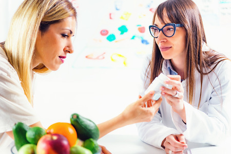 Doctor nutritionist, dietician and female patient on consultation in the officeの写真素材