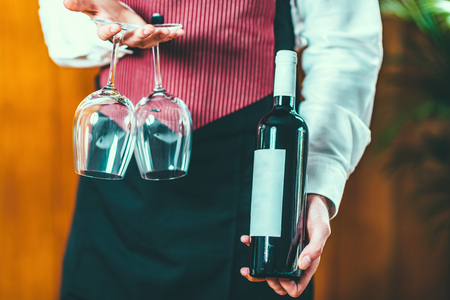 Sommelier holding wine bottle and wine glassesの写真素材