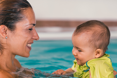 Mother with cute baby boy in the swimming poolの写真素材