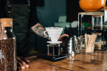 Close up of Drip coffee maker, kettle with thermometer and digital scale on wooden table.の写真素材