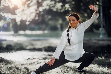 Woman practicing Tai Chi Quan in the parkの写真素材