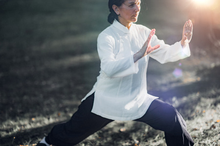 Woman practicing Tai Chi Quan in the parkの写真素材