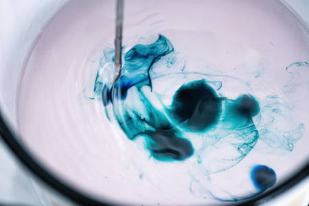 Close up of coloring candles process. Melted green color dye blocks with transparent white wax.の写真素材