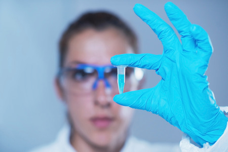 Young female scientist holding micro test tubeの写真素材