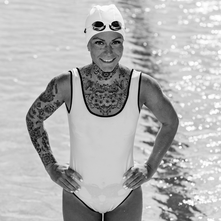 Portrait of female with tattoos posing by the poolの写真素材
