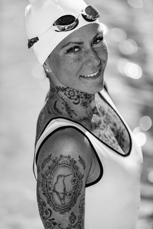 Portrait of female with tattoos posing by the poolの写真素材