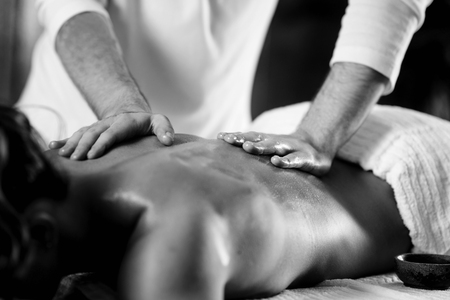 Close up of young woman with oiled skin having relaxing back massageの写真素材