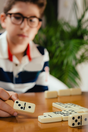Dominoes. School boy playing dominoes. Having fun.の写真素材