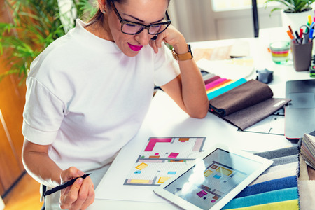 Female architect, decorator, drawing floor plan in her officeの写真素材